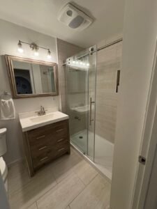 modern full bathroom remodel with new vanity, tile shower, and upgraded lighting
